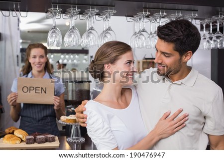 Loving couple with female cafe owner at the coffee shop