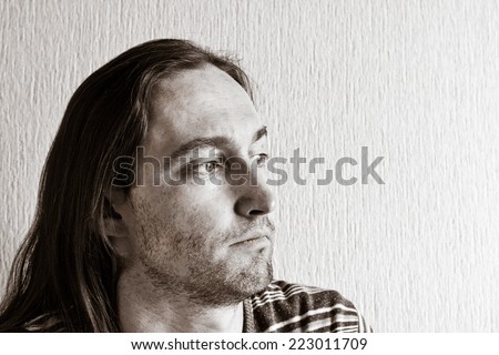 Portrait of long hair handsome thinking man. Black and white image
