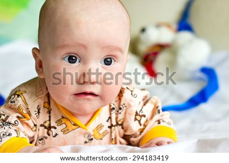 Newborn baby boy sad portrait with teddy bears and blue ribbon