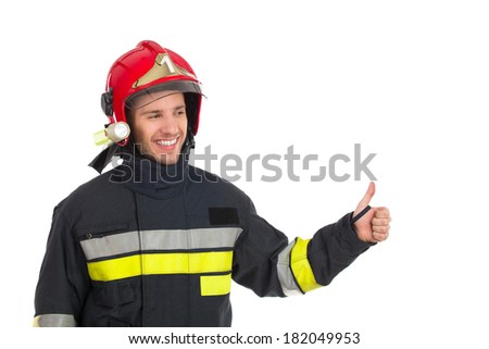 Smiling fireman showing thumb up and looking at camera. Waist up studio shot isolated on white.