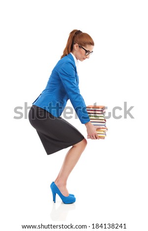 Crouching with heavy stack of books. Elegance woman picking up heavy stack of books. Full length studio shot isolated on white. Side view.