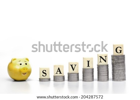 stacks of coins arranged as a graph shape with a word saving and a yellow saving pig / saving money