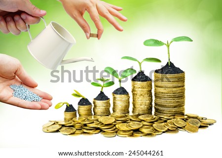 Cooperation - Hands helping planting trees growing on coins together with green background - Building business with csr and ethics
