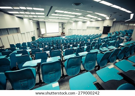 An empty large lecture room / University classroom with blue chairs