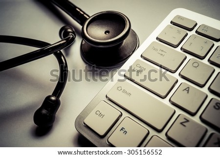 Stethoscope with computer keyboard - computer system maintenance and check concept