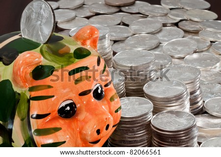 Colorful piggy bank and silver dollars