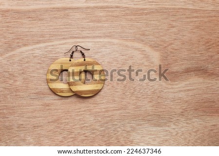 Wooden earrings. Fashion accessories on wooden surface. Hipster lifestyle.
