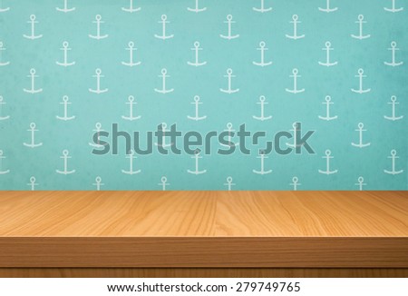 Empty wooden table over vintage wallpaper with a pattern of anchor. Ready for product montage display