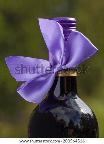 Red wine bottle with purple bow