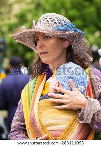 STOCKHOLM, SWEDEN - MAY 31, 2015. Peace and Love Parade. Street party in Stockholm, Young woman carrying little baby