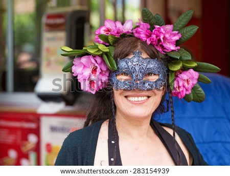 STOCKHOLM, SWEDEN - MAY 31, 2015. Peace and Love Parade. Street party in Stockholm, woman with facial mask and flowers in her hair.