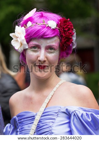 STOCKHOLM, SWEDEN - MAY 31, 2015. Peace and Love Parade. Street party in Stockholm. Woman with bright colors, flowers and purple wig.
