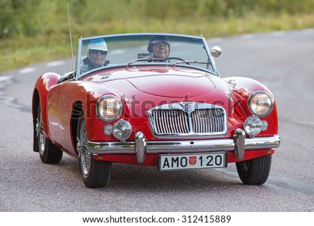 MORKO SWEDEN, June 25 2015. MGA SPORT 1958 red. Elderly couple in a beautiful MG Driving on the highway.