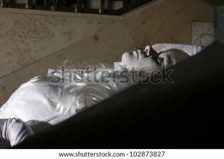Beautiful princess all in white with a little crown laying on the stairs