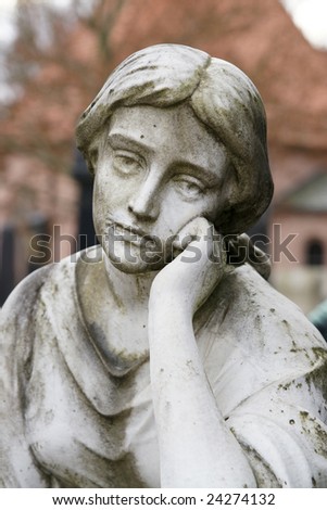 Ancient female sculpture at a gravestone in a grave yard