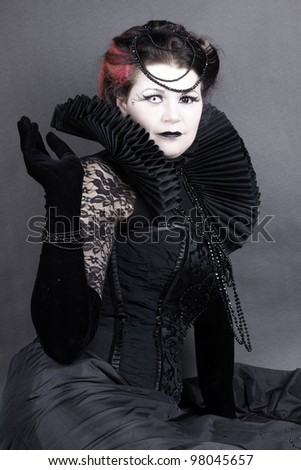Woman dressed up in gothic style as dark queen in ancient victorian clothing