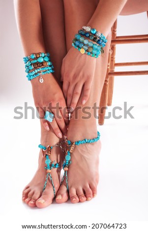 Woman posing with summer styles bracelets and rings, studio shot