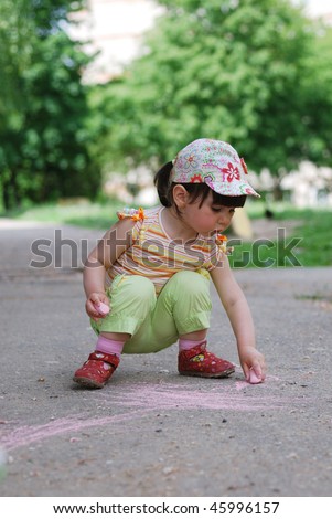 small girl drawing on the sidewalk with chalk