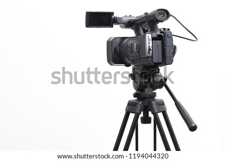 The video camera with the microphone is standing on the tripod isolated on white, in concept of technology, modern, entertainment. Сток-фото © 