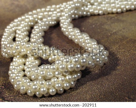 strands of pearls on dark  textured background