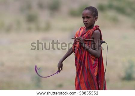 SERENGETI, TANZANIA - JUNE 6: Unidentified Masai People walk in the Africa bush to protect cattle on June 6, 2010 in the Serengeti, Tanzania.