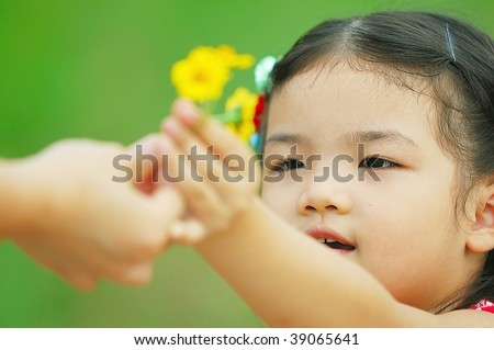 Cute Asian little girl gives flower to her mother