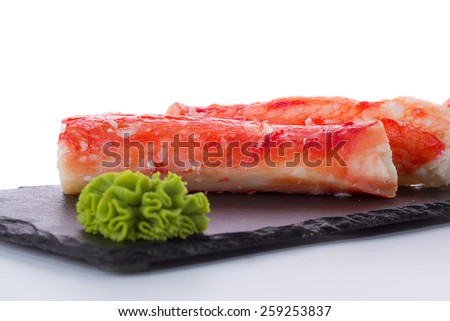 Crab sticks on stone plate isolated on white background