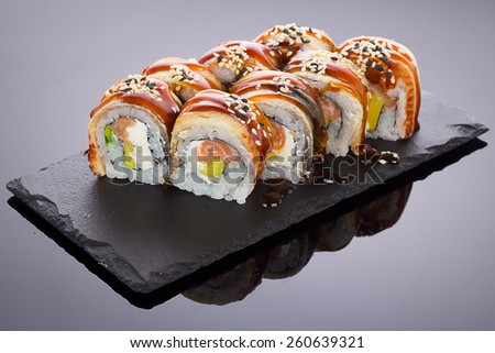 Eel sushi on a stone plate over black background