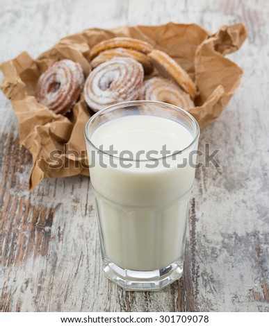 Seet fresh cookies with a cup of milk over wooden vintage background