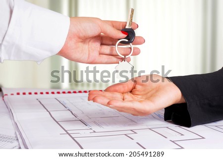 Architect hand presenting house key to a client.