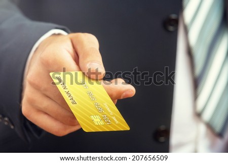 Close up of a businessman`s hand,holding gold credit card.