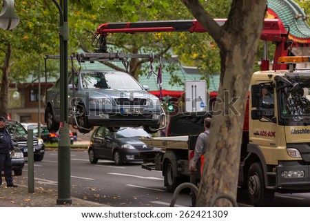 Berlin, Germany - Oct 17, 2012: A car being towed away from a street in Berlin with the help of car wreckers and police.