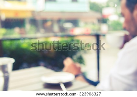 People drink coffee at the coffee shop, and the image is blurred and the image vintage.