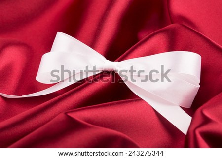 White ribbon satin bow on the nice red silk
