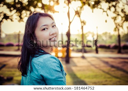 Summer girl portrait. Asian woman smiling happy on sunny summer or spring day outside in park ,process color