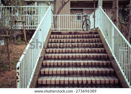 Old stairs with a bicycle parked at the top in japan, process color