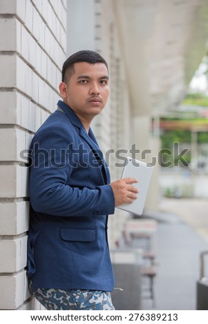 Young businessman Using Tablet Computer happy outside building.
