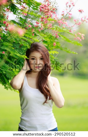 Portrait asian young long-haired girl in a white vest on park background