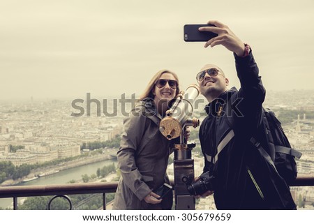 PARIS, FRANCE - JUNE 5 2015:Tourist selfie on Eiffel Tower is the most visited monument in France and the most famous symbol of Paris, June 5, 2015, process color.