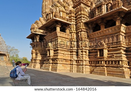 Khajuraho, Madhya Pradesh , India - March 2011 :  Foreign visitor studying at Lakshmana Temple, dedicated to Lord Vishnu, Western Temples of Khajuraho on 21st March, 2011. UNESCO world heritage site.