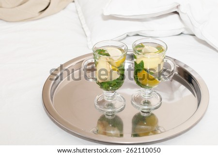 Drink with  mint leaves and lemon ginger Drink with  mint leaves in transparent cup and lemon ginger bed background