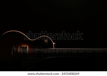 Similar – Image, Stock Photo A black guitar head with the golden tuning pegs and the plastic and metal sides attached to the white screws. A small part of the fingerboard is still visible.