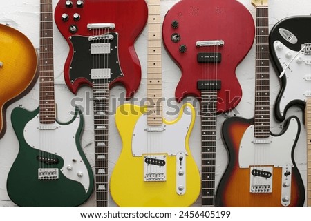 Similar – Image, Stock Photo A black guitar head with the golden tuning pegs and the plastic and metal sides attached to the white screws. A small part of the fingerboard is still visible.