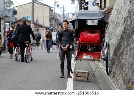 KYOTO, JAPAN - DECEMBER 30, 2014 : young tour guide on a street in Kyoto by rickshaw.Rickshaw is a popular mode of transportation in Japan.