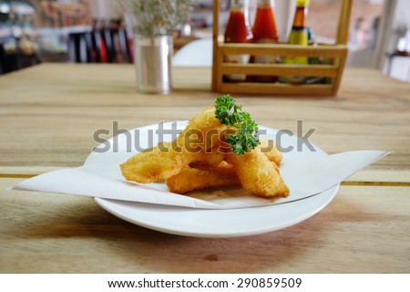 fried fish fingers on wooden table