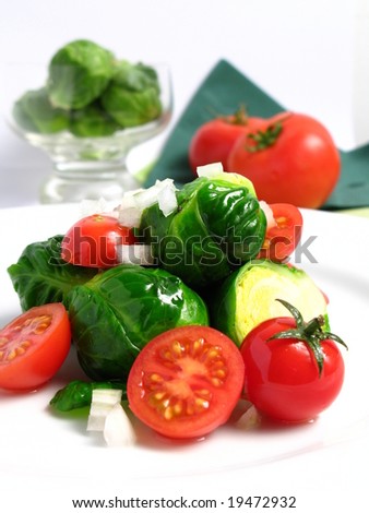 Fresh organic salad of Brussels sprouts and cherry tomatoes, on white dish