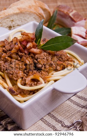 Bolognesa Pasta with bacon and bread on a handmade mat