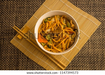 Fried noodle.  Yakisoba with beef, ticken and vegetables in a white bowl on a dark background. Asian cuisine meal. Stock foto © 