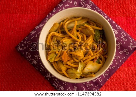 Fried noodle.  Yakisoba with beef, ticken and vegetables in a white bowl on a red background. Asian cuisine meal. Stock foto © 