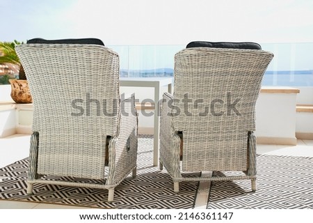 two white rattan armchairs on a balcony in the sun overlooking the sea Stock foto © 